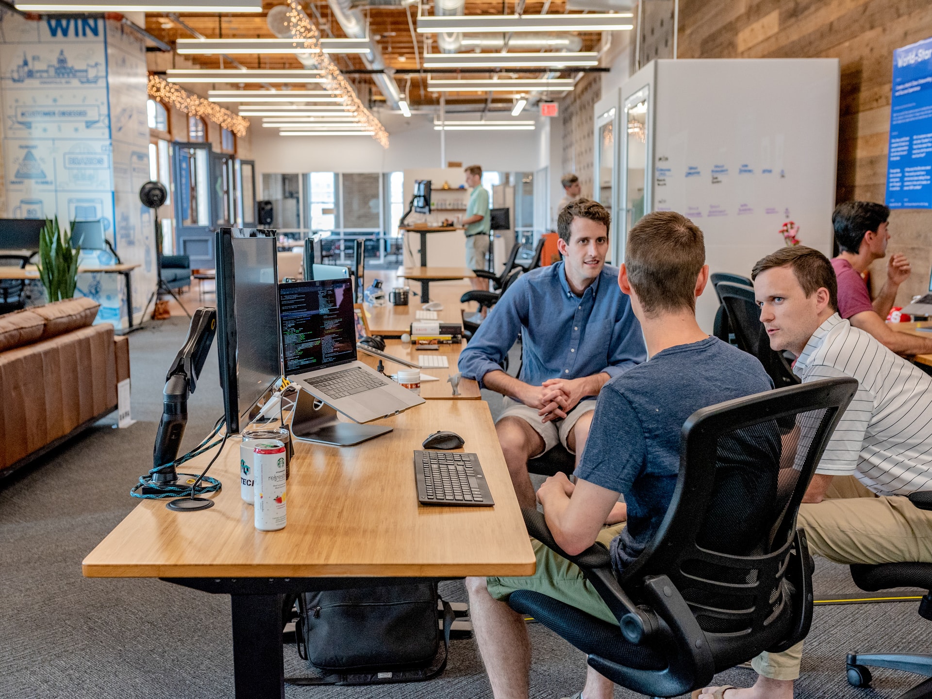 three white men talking in office setting